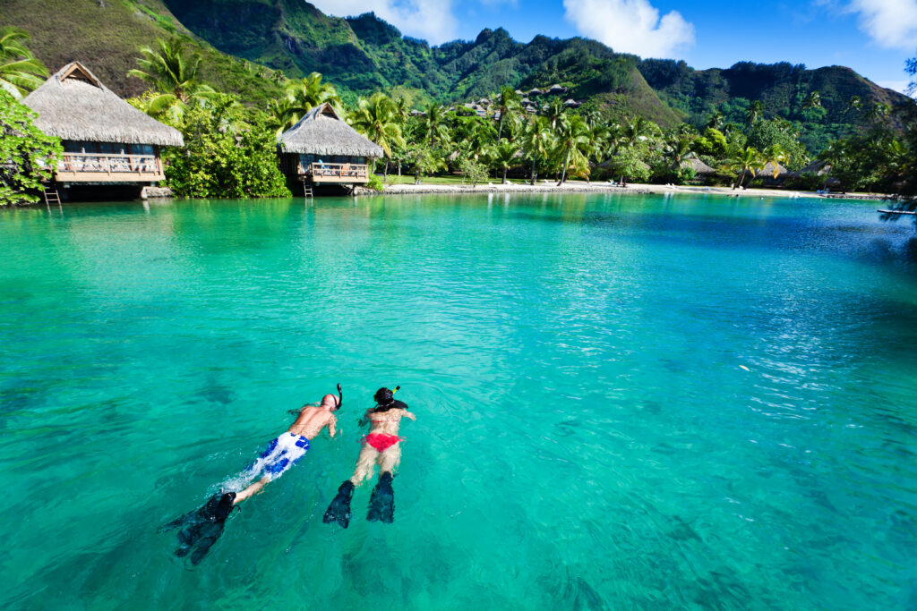 Young couple snorkeling in clean water over coral reef